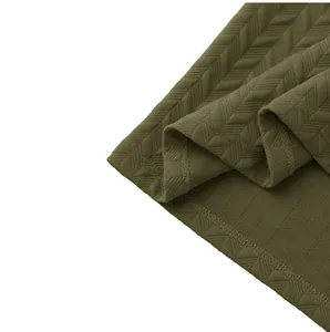 Detailed view of olive green heavy jacquard polo shirt with chevron texture and hem