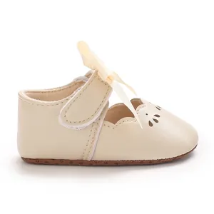 Vista lateral de zapato de princesa para bebé crema con lazo grande y detalles calados