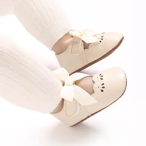 Primer plano de zapatos princesa para bebé niña beige con lazo grande y calados