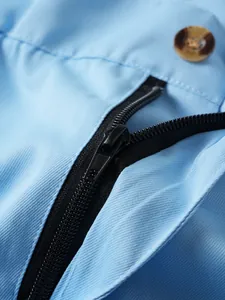 Nahaufnahme des schwarzen Reißverschlusses und des Knopfes an den blauen Herren-Sportshorts