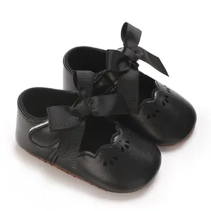 Primer plano de zapatos de princesa para bebé negros con lazos grandes y calados florales