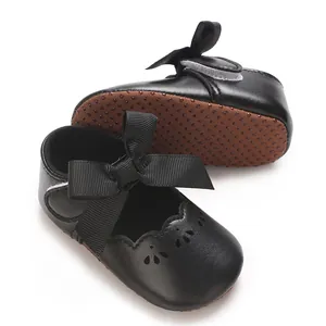 Vista lateral de zapatos de princesa para bebé negros con lazo grande y suela blanda