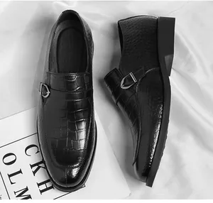 Detailed view of men's elegant black monk strap shoes featuring a crocodile skin texture.