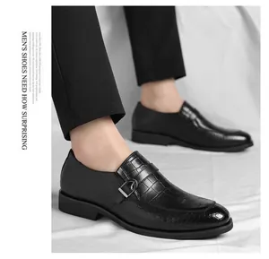 Close-up view of black men's leather shoes with crocodile texture and buckle detail