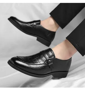 Close-up of black monk strap men's shoes with crocodile texture on a white background