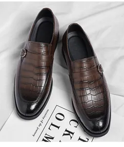 Close-up detail of men's brown crocodile texture leather loafers with elegant metal buckle