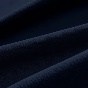 Gros plan sur la texture du tissu en maille piquée bleu marine respirant d'un polo homme