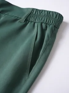 Nahaufnahme von elastischem Bund und Seitentasche bei dunkelgrünen Herren-Sportshorts