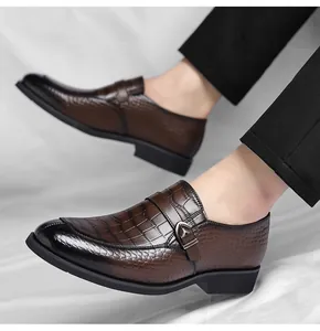 Close-up of men's brown business loafers with crocodile embossed leather and buckle detail