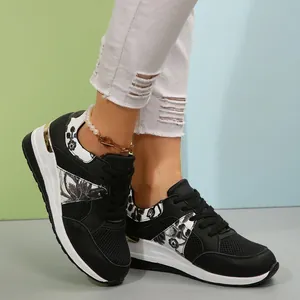 Κοντινό πλάνο ασπρόμαυρων sneakers με πλατφόρμα, φλοράλ σχέδια και λεπτομέρειες mesh.