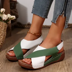 Primer plano de sandalias con cuña para mujer con correas cruzadas en verde y blanco