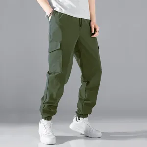 Gedetailleerd zicht op een olijfgroene heren cargo joggingbroek met elastische boorden.