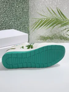 Λεπτομέρεια λευκού sneaker με πλατφόρμα που δείχνει την πράσινη αντιολισθητική σόλα.