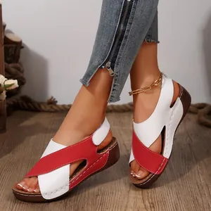 Detail of red and white wedge sandals featuring hook-and-loop straps and peep-toe design