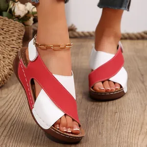 Primer plano de sandalias de cuña para mujer con correas cruzadas rojas y blancas