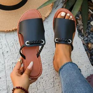Stylish black flat sandals for women featuring a braided strap and comfortable brown sole