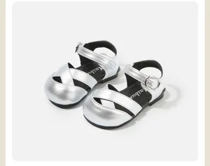 Detailed view of metallic silver toddler sandals featuring criss-cross straps and adjustable buckle
