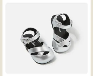 Close-up view of silver metallic baby sandals featuring crossover straps and buckle