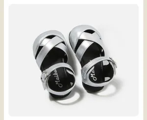 Macro view of silver metallic baby toddler sandals with elegant criss-cross straps