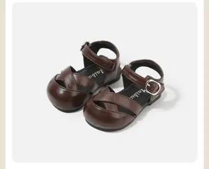 Detailed view of brown crossover strap sandals for toddler girls with buckle closure
