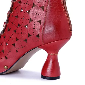 Detalle en primer plano de botas de cuero rojo con patrones calados y elegante tacón