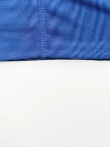 Close-up of blue ribbed knit fabric and neat stitching on men's sports vest.