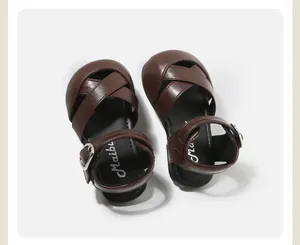 Detailed overhead view of brown toddler girl sandals with cross strap leather design