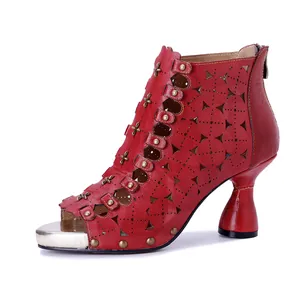 Vista lateral de botines de cuero rojos hechos a mano con tachuelas y calados