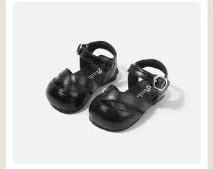 Detail view of black toddler sandals with hollow cross-strap design and buckle.