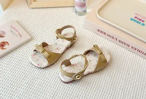 High-angle view showing the delicate floral pattern and bow detail on girls sandals