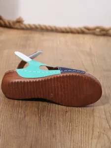 Detail view of anti-slip outsole and color-block upper of women's wedge sandal