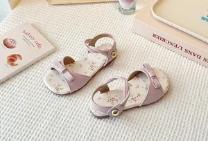 Detail of girls' pink floral sandals with elegant bow and comfortable flat sole