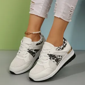 Λεπτομέρεια λευκών γυναικείων sneakers πλατφόρμα με δίχτυ και λουλουδάτο κέντημα