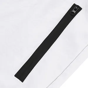 Macro view of high-quality black waterproof zipper detail on white athletic shorts fabric
