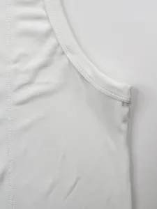 Close-up of white ribbed fabric and durable stitching on a men's athletic tank top.