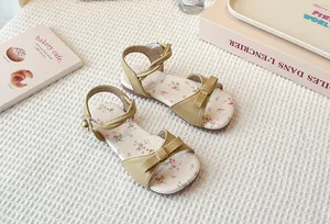 Detailed top-down view of girls' floral flat sandals with bow and beige ankle strap