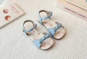 Close-up of children's light blue floral sandals with bow detailing and ankle strap.