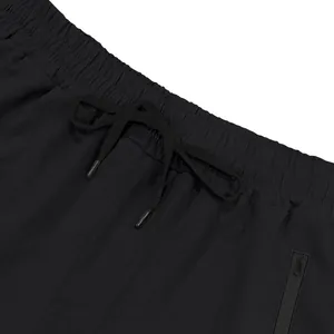 Detailed view of elastic waistband and black drawstring on men's sports shorts.