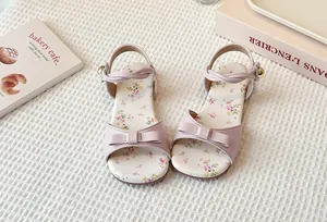 Close-up of pink girl's sandals with floral print insole and bow decoration detail