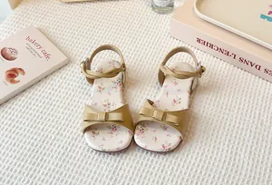 Detailed view of stylish girl's floral flat sandals with bow and patterned insole design.