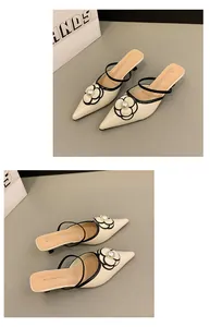 Vue détaillée de mules crème à bout pointu avec fleur de perle et bordure noire chic