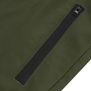 Close-up view of the high-quality black zipper pocket detail on olive green sports shorts.