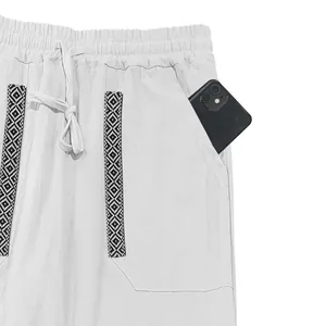 Detail of men's bohemian linen pants showing the side pocket and decorative trim