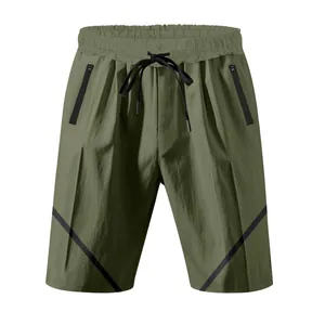 Detail view of olive green athletic shorts with drawstring waist and zipper pockets