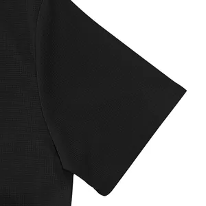 Detailed close-up view of breathable black waffle knit fabric on men's polo shirt sleeve