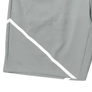 Nahaufnahme grauer Sportshorts mit einem markanten weißen diagonalen Streifenmuster