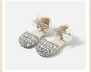 Dettaglio di scarpe da neonata con strass argentati ed elegante fiocco in mesh bianco