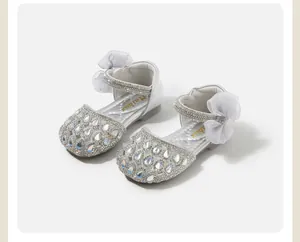 Dettaglio scarpe da principessa per neonata in argento con strass e fiocco in tulle