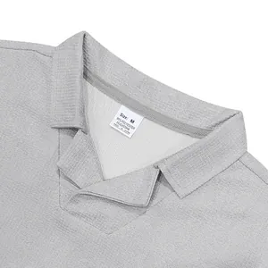 Vue détaillée du polo gris en maille gaufrée avec col Burke et étiquette de taille