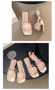 Primer plano de elegantes sandalias rosa claro con flores que presentan un acabado de satén
